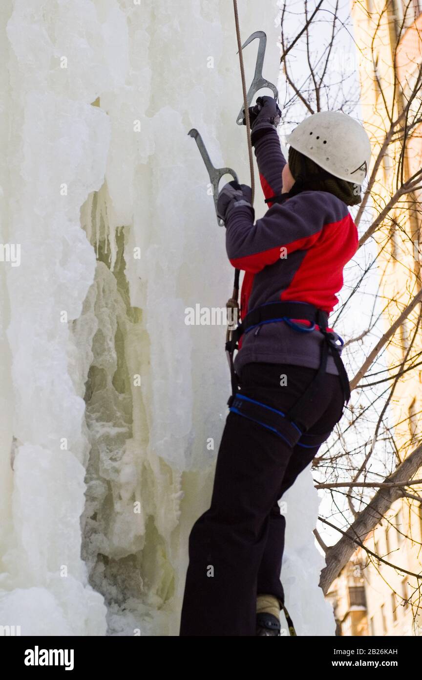 Mädchen klettert auf Eis Kletterwettbewerb nach oben Stockfoto