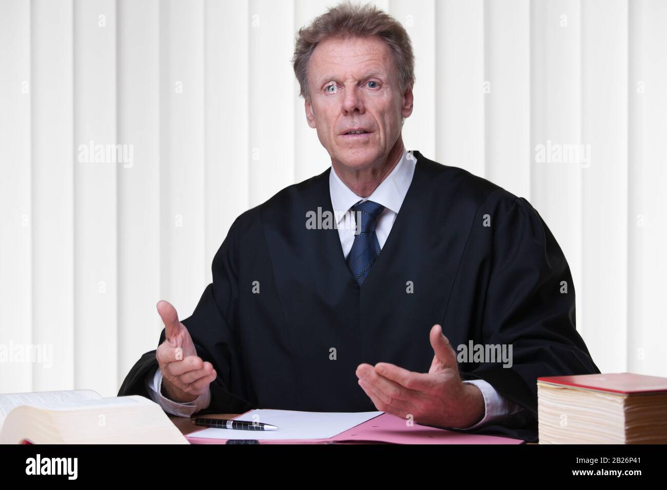 Richter oder Anwalt an seinem Schreibtisch in einem hellen Gerichtssaal Stockfoto