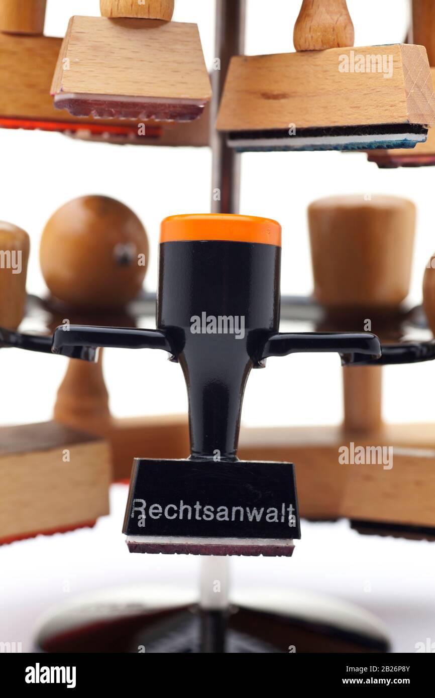 Nahaufnahme eines Stempelhalters mit vielen Stempeln - einer davon mit dem deutschen Wort für Advokat, Anwalt oder Anwalt Stockfoto