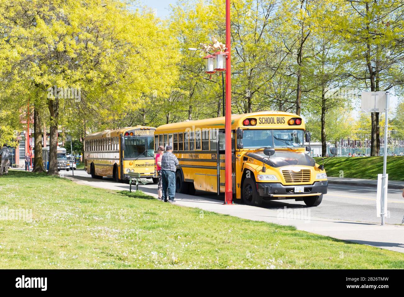 Vancouver - 05. Mai 2019: Downtown Vancouver, Kanada. Klassische gelbe Schulbusse parkten am Eingang von Chinatown, Vancouver, BC. Stockfoto