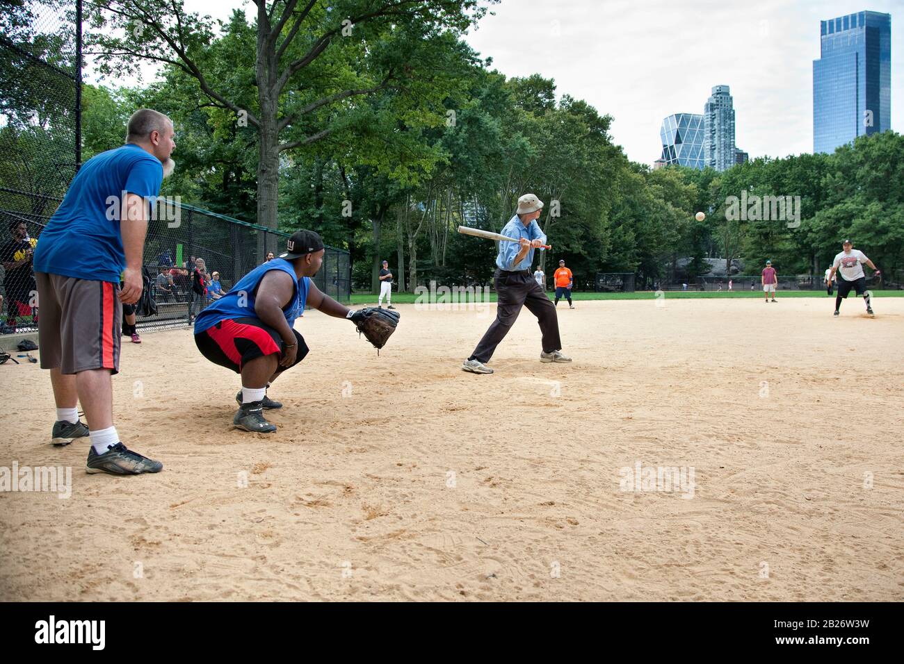 Softballspiel auf Heckscher Ballfields mit Senior man, Central Park, NYC Stockfoto