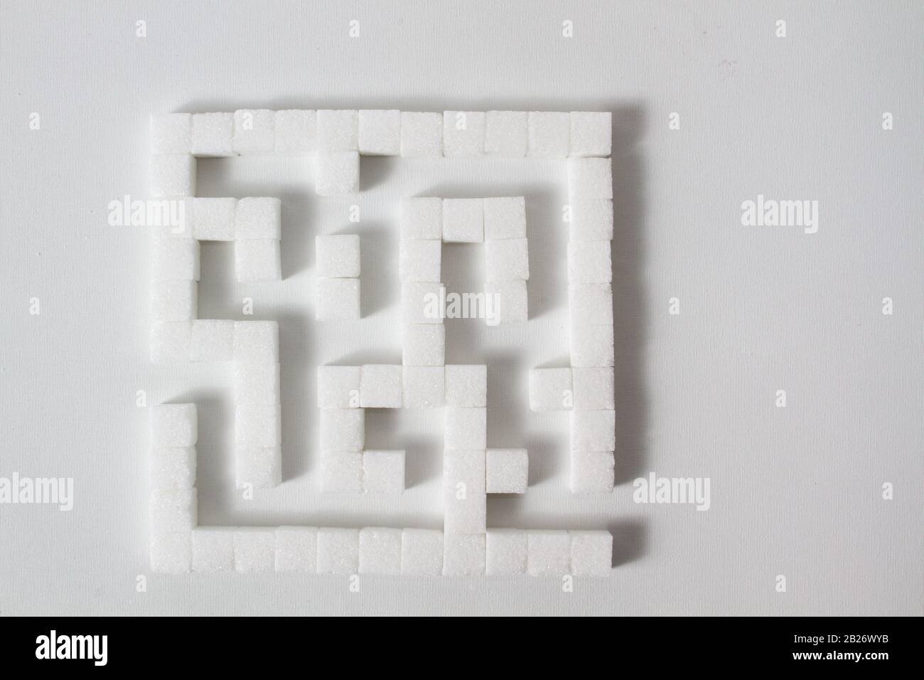 High Key Detail eines Labyrinths aus Zuckerwürfeln, die als Symbol für ungesunde Essgewohnheiten Stockfoto