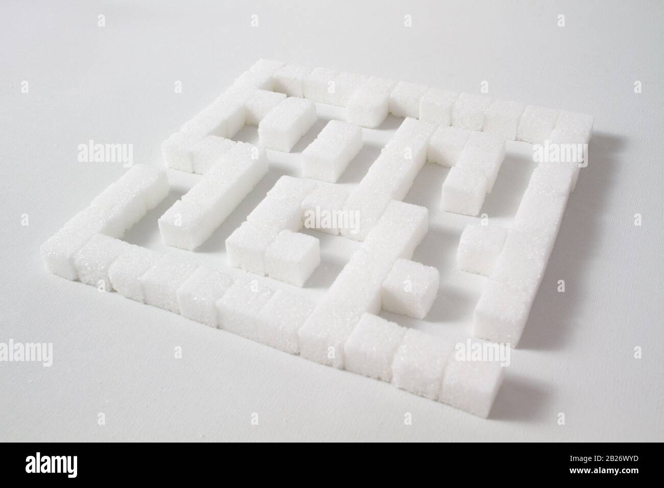 High Key Detail eines Labyrinths aus Zuckerwürfeln, die als Symbol für ungesunde Essgewohnheiten Stockfoto