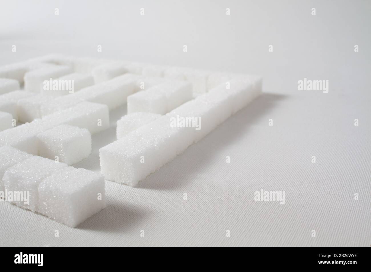 High Key Detail eines Labyrinths aus Zuckerwürfeln, die als Symbol für ungesunde Essgewohnheiten Stockfoto