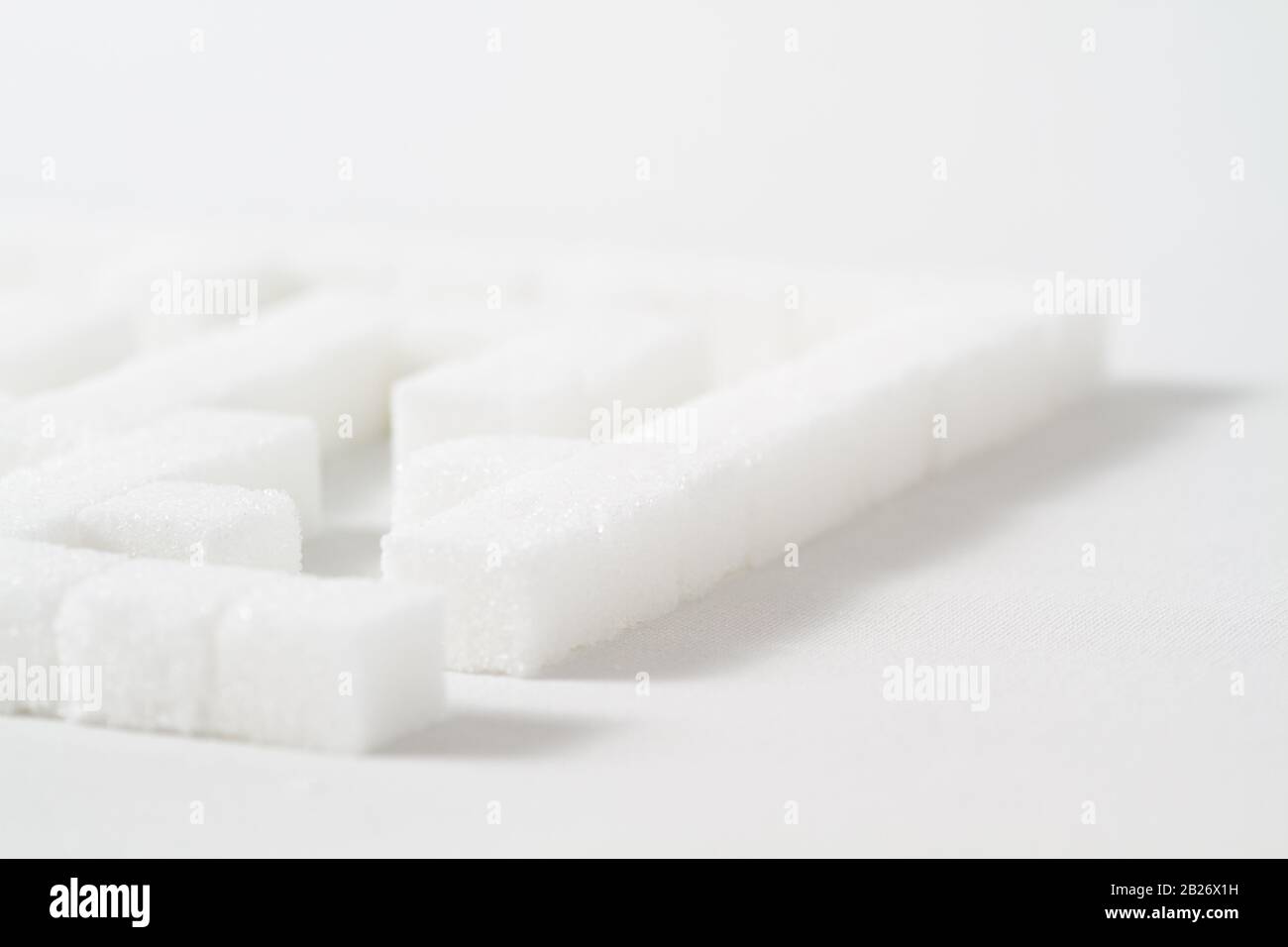 High Key Detail eines Labyrinths aus Zuckerwürfeln, die als Symbol für ungesunde Essgewohnheiten Stockfoto