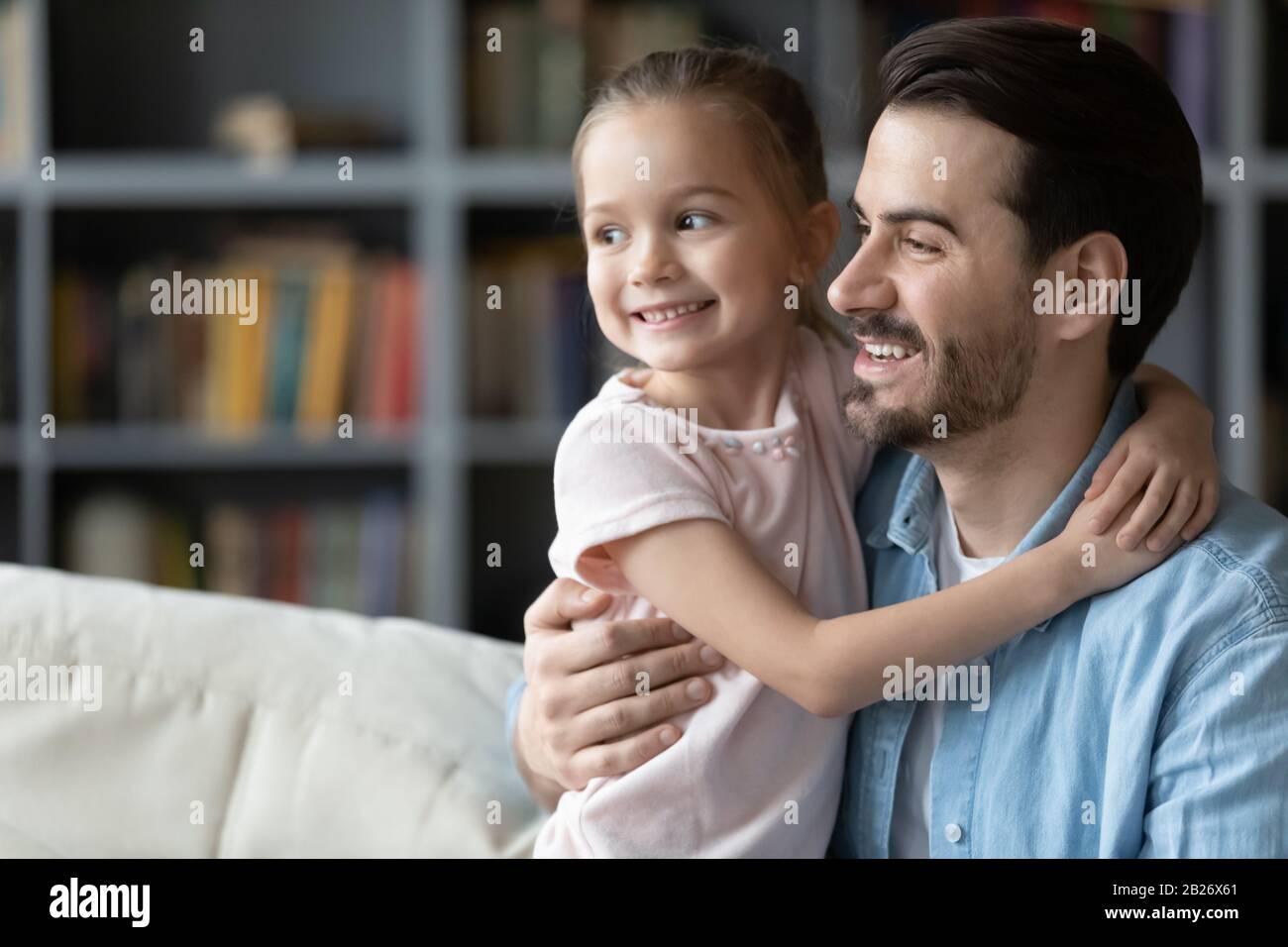 Lächelnder junger Vater und kleine Tochter visualisieren sich zuhause Stockfoto