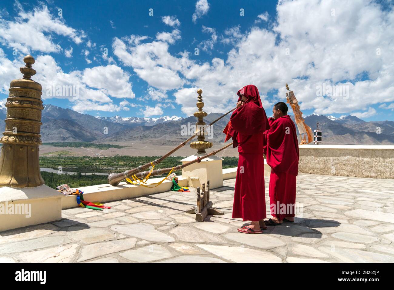 Zwei junge tibetisch-buddhistische Mönch, die auf dem Dach des Klosters Thiksay in LEH, Ladakh, Hörner blasen Stockfoto