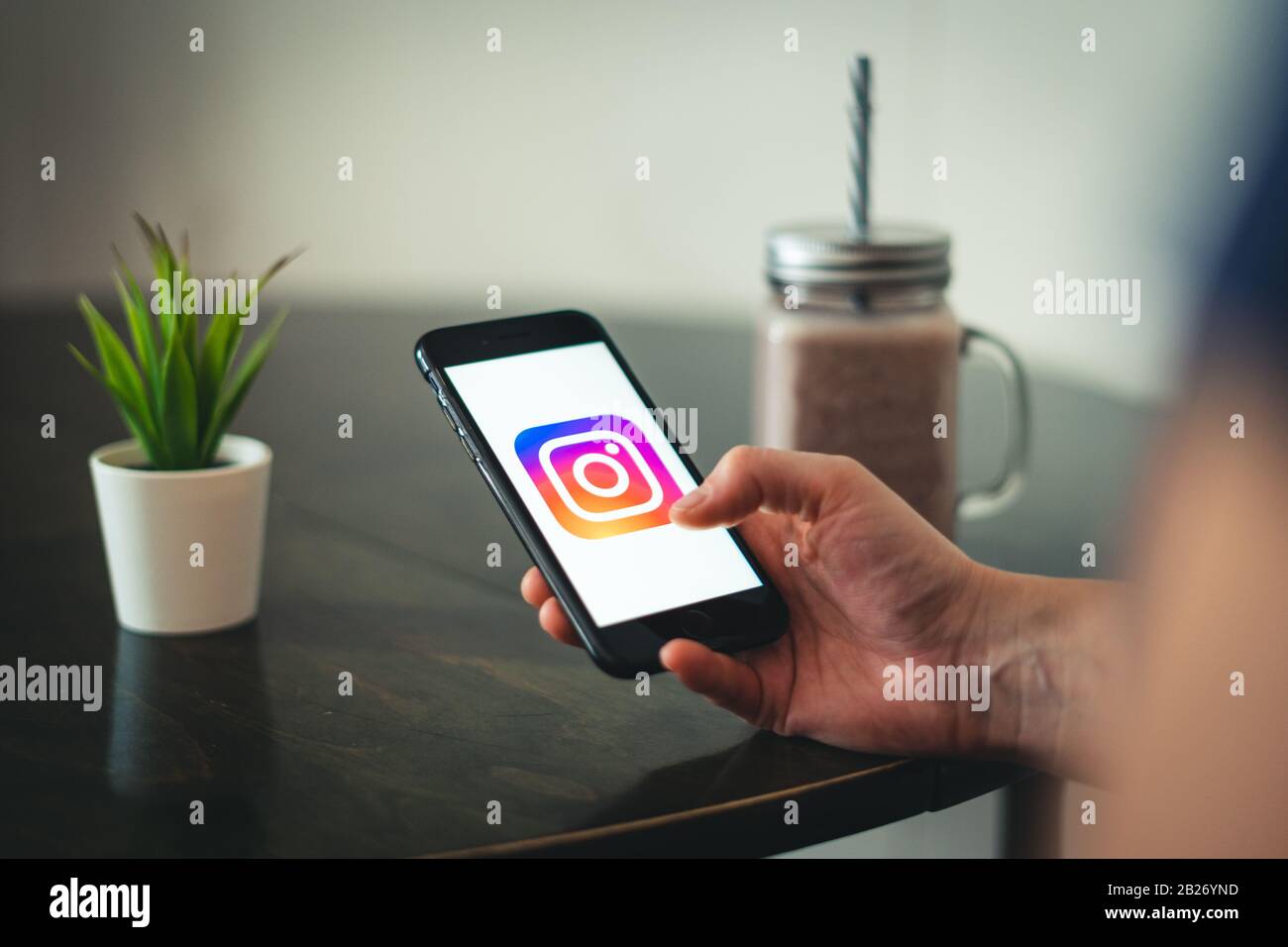 Telefon in Händen, die durch Instagram scrollen. Ein süchtiger Mensch in den sozialen Medien. Junge Leute verbringen viel Zeit am Telefon und Stockfoto
