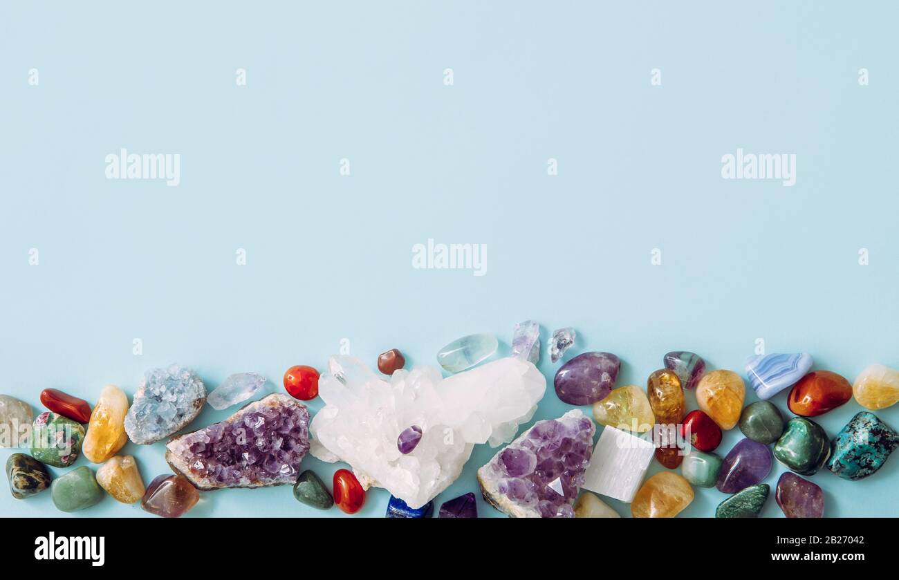 Rahmen aus vielen verschiedenen rohen natürlichen Kristallgeode-Clustern, Amethyst, Celestit, Quarz auf hellblauem Hintergrund für den Kopierraum. Stockfoto