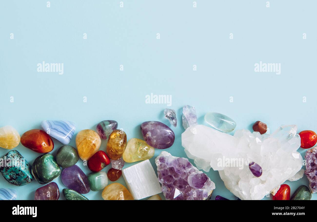 Rahmen aus vielen verschiedenen rohen natürlichen Kristallgeode-Clustern, Amethyst, Celestit, Quarz auf hellblauem Hintergrund für den Kopierraum. Stockfoto