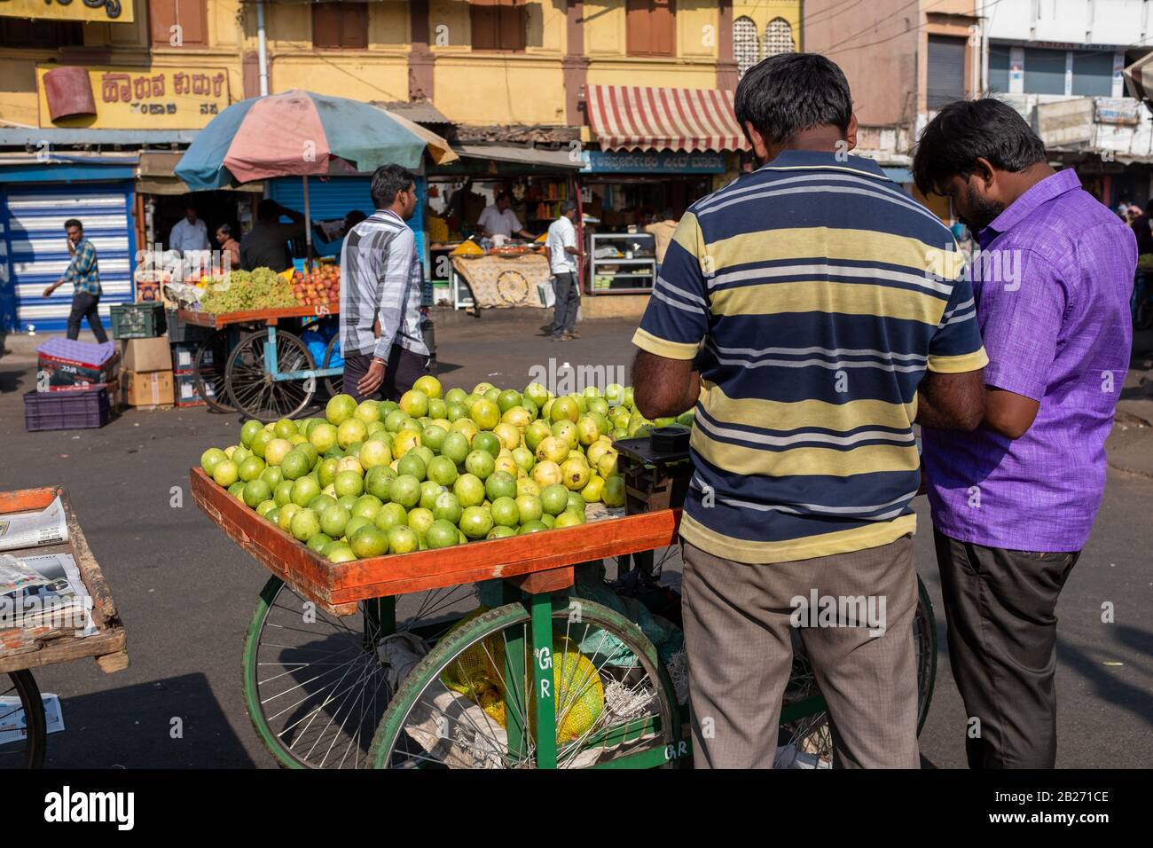 Mysore, Indien - 12. März 2018: Zwei Verkäufer, die Guava-Früchte auf einem externen Bauernmarkt in Mysore verkaufen, am Morgen eingenommen in Indien. Stockfoto