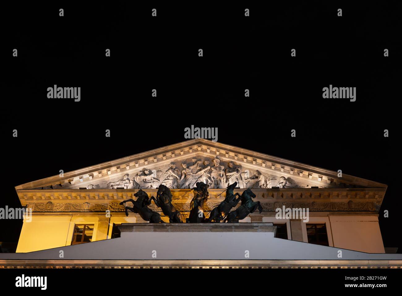 Das große Theater und die Nationaloper in der Warschauer Stadt, Polen, die Apollo Quadriga-Skulptur und -Pediment über dem Eingang, architektonische Details in der Nacht Stockfoto