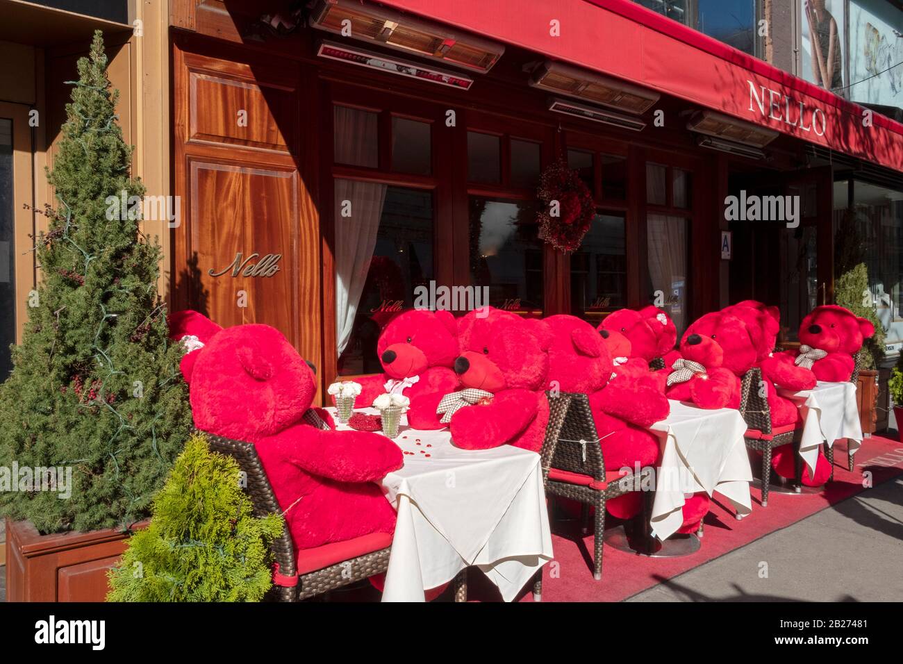 Am Valentinstag sitzen 12 riesige rote gefüllte Bären an Tischen im Nello's für Nachmittagstee. An der Madison Avenue auf der East Side von Manhattan, Stockfoto