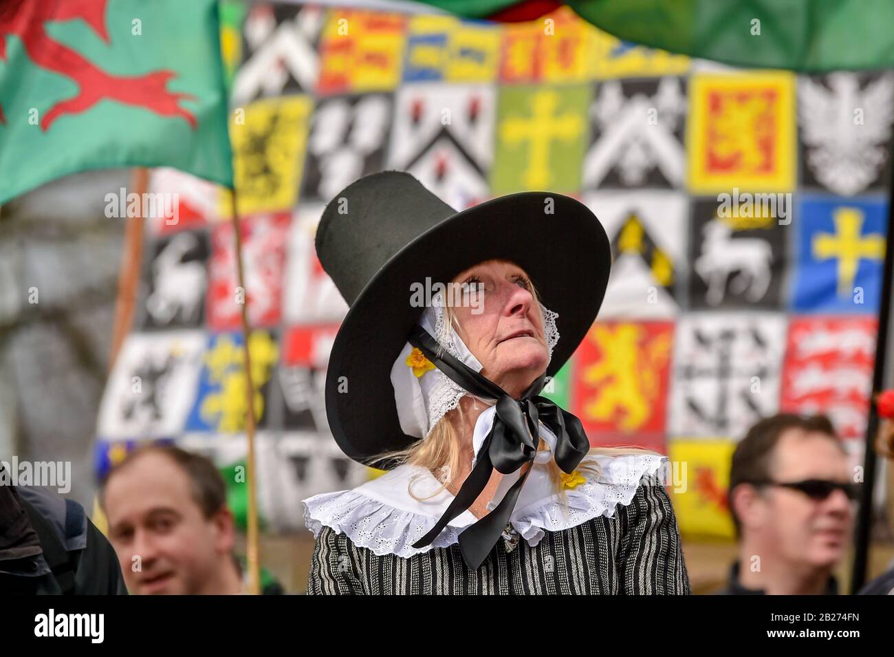 Eine Frau trägt traditionelles walisisches Kleid während der St David's Day Parade in Cardiff, bei der Hunderte von Menschen in der Feier des Schutzpatrons von Wales, Dewi Sant (Saint David in English), der während des 6. Jahrhunderts walisischer Bischof von Mynyw (heute St Davids) war, durch die Stadt marschieren. Stockfoto