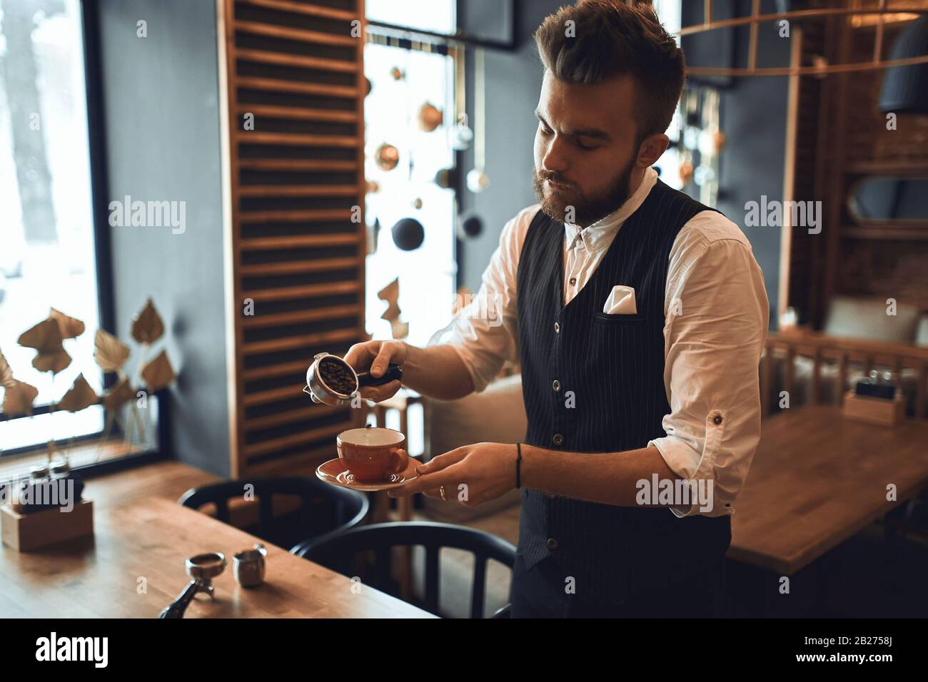 Junger Mann in Mode, der lernt, Kaffee zu machen, Nahaufnahme Foto. Stockfoto