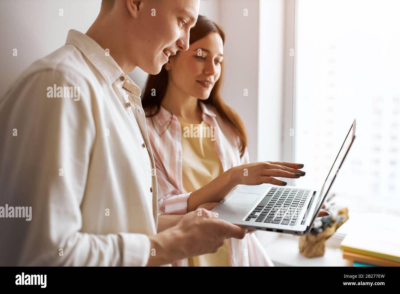 Junge Leute, die online plaudern, betäuben, Seitenansicht aus nächster Nähe Foto.Paar auf der Suche nach einer Wi-Fi-Verbindung. Seitenansicht Foto.Mann und Frau einkaufen Stockfoto