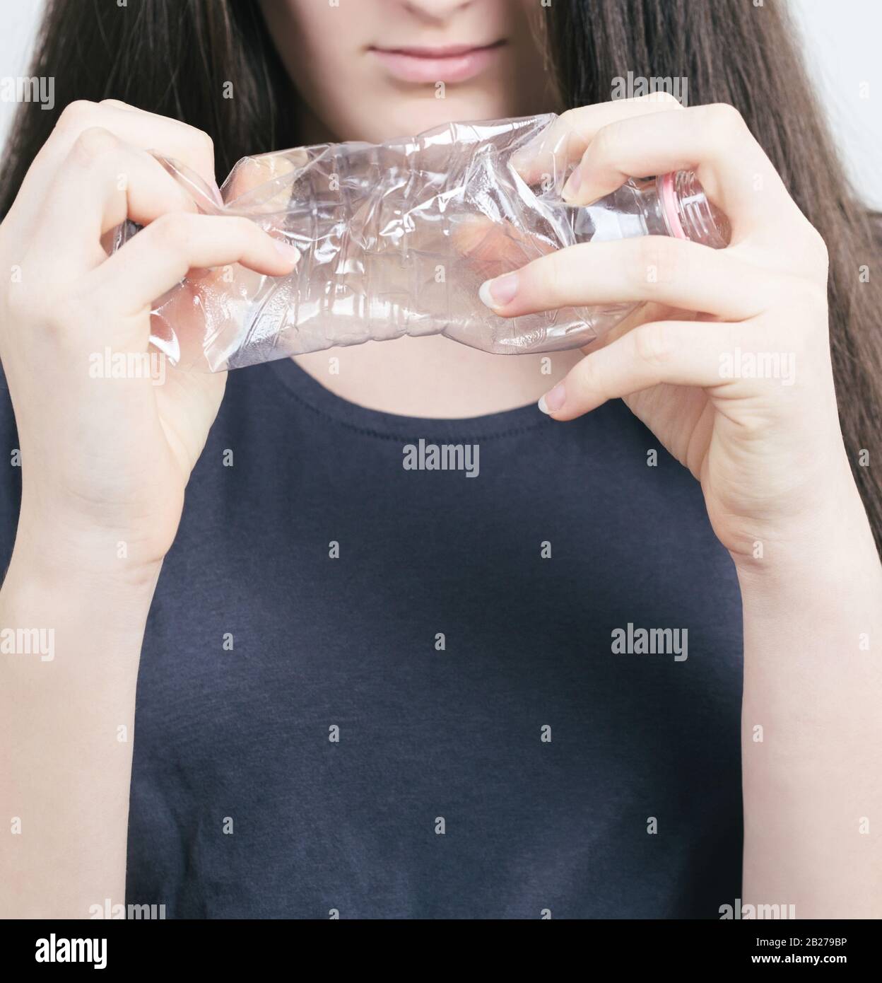 Brünette Teen Girl Squashing Plastikflasche Closeup Stockfoto