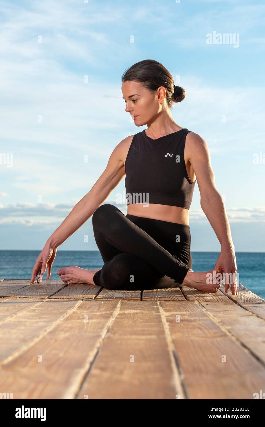Frau, die morgendliche Meditation in der Natur am Meer praktiziert, gesundes Lebenskonzept. Stockfoto