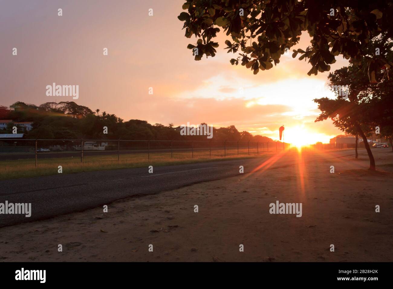 Der Himmel beleuchtete leuchtend orange, hellviolett an den äußeren Randzonen von den Sonnenstrahlen, die von einem am meisten anziehenden Sonnenuntergang über dem Vigie-Flughafen, Saint Lucia, stammen Stockfoto