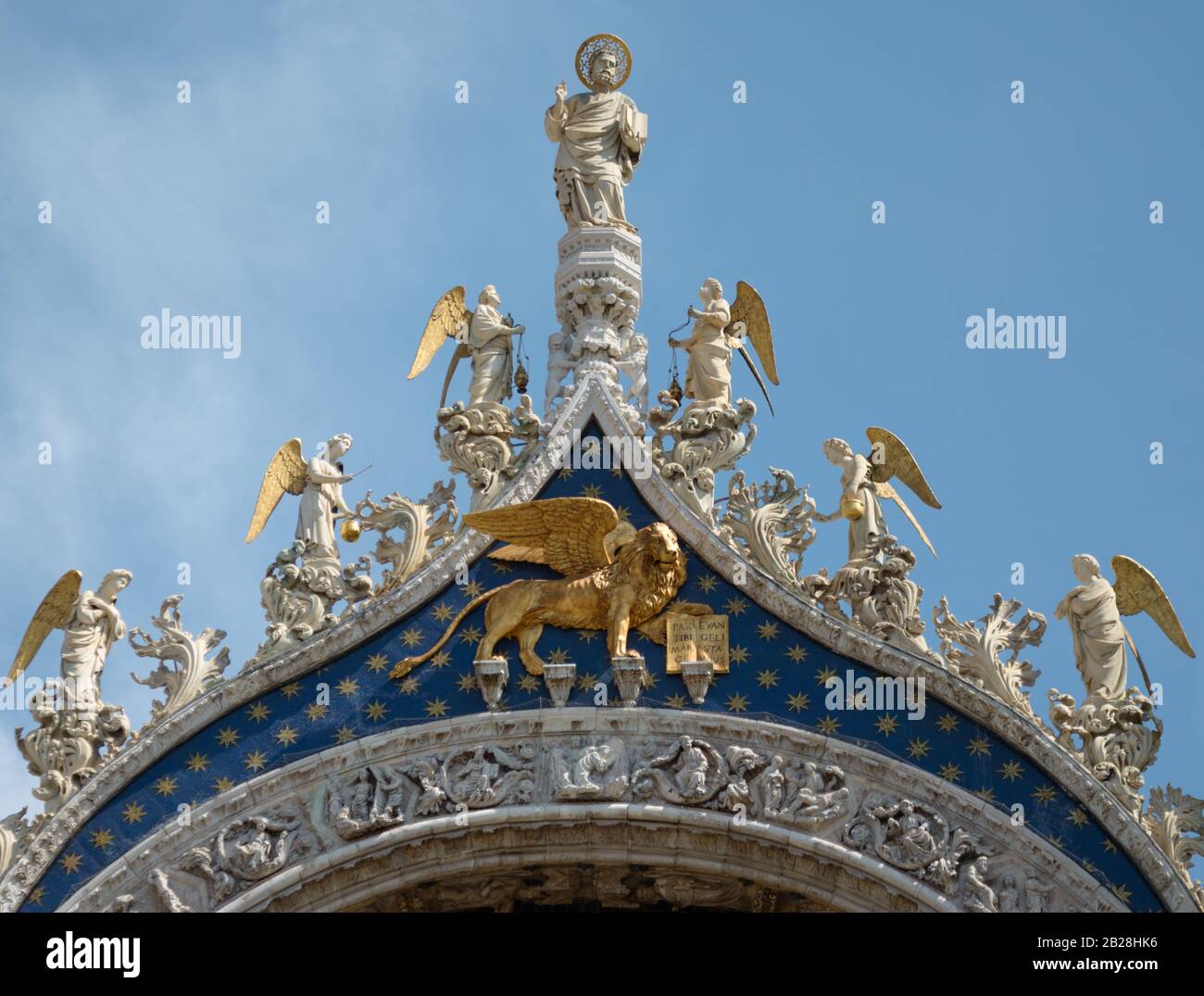 Statue des Heiligen Markus Apostel, Engel und ein goldener Löwe. Architektonische Detail der Fassade Kathedrale Basilika San Marco, Venedig/Italien. Stockfoto