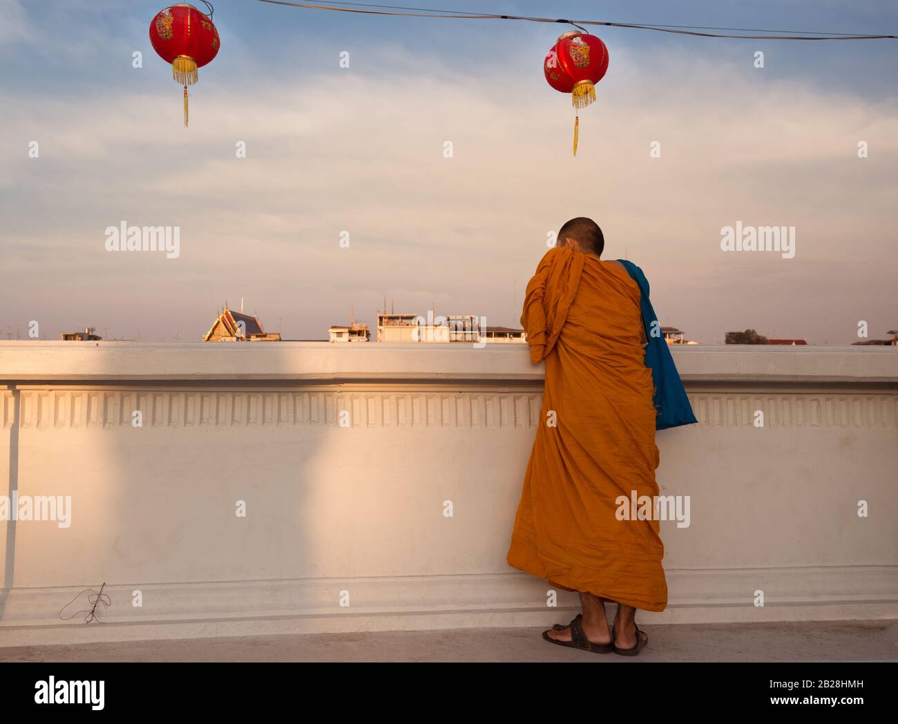 Buddhistischer Mönch steht hinter der Wand und blickt auf den Chao Phraya Fluss in Bangkok, Thailand friedliche Szene mit buddhistischem Mönch Stockfoto