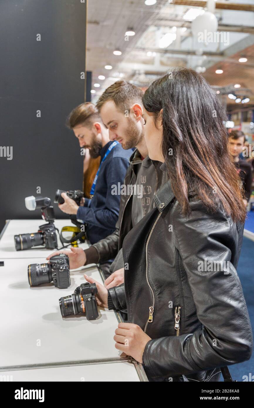 Kiew, UKRAINE - 06. APRIL 2019: Jugendliche, die während der CEE 2019 professionelle Fotokameras auf dem Nikon-Stand testen, der größte Elektronikhandel s. Stockfoto