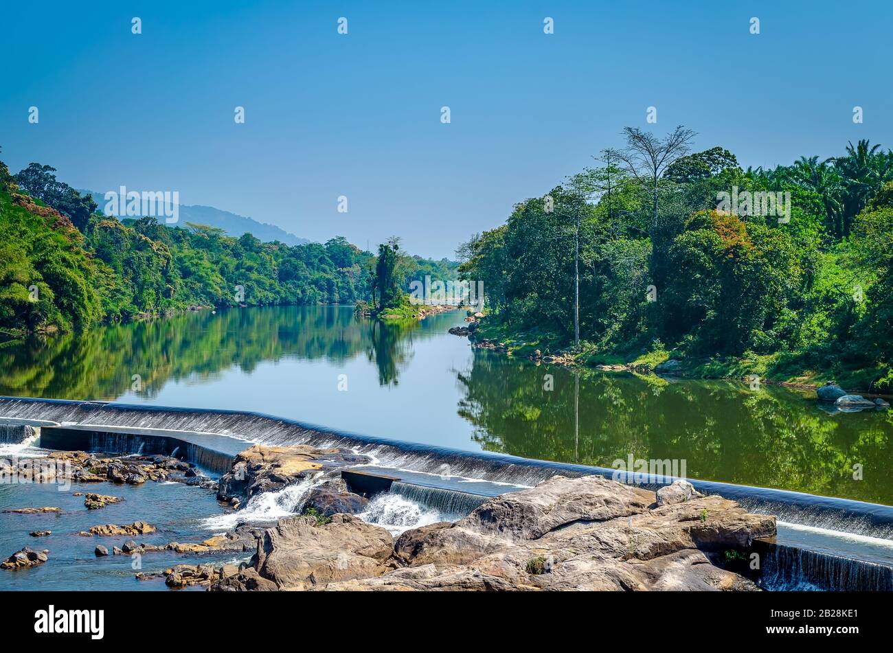 Wasser, das über einen kleinen Staudamm im Fluss fließt. Schöne Landschaft. Aus Kerala, Indien. Stockfoto