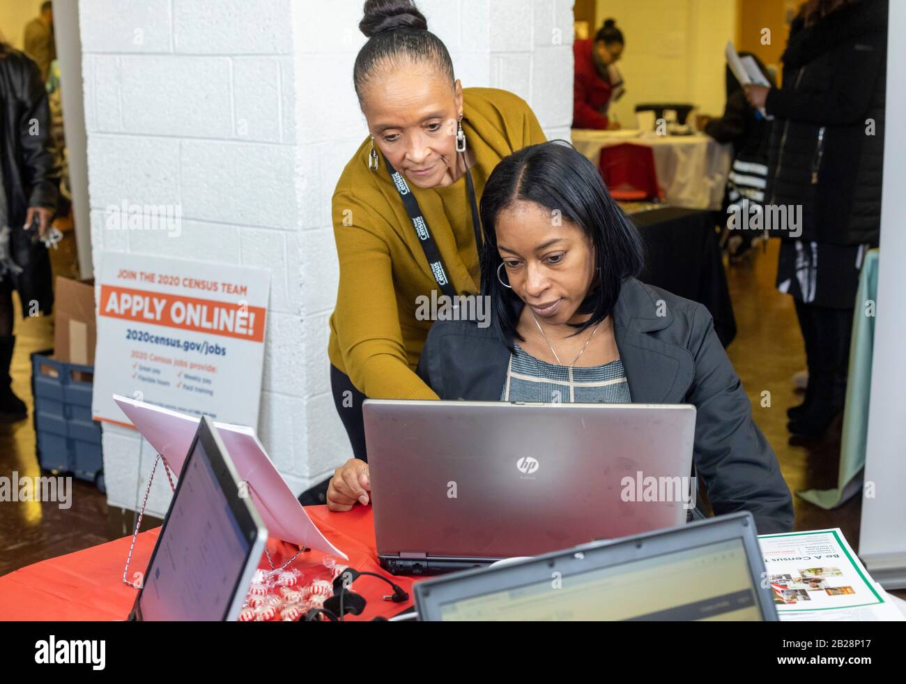 Detroit, Michigan, USA. März 2020. Juanita Brown (Stand), eine Census Job Recruiterin, hilft einer Frau, sich während einer Jobmesse in der Martin Evers Missionary Baptist Church beim U.S. Census zu bewerben. Kredit: Jim West/Alamy Live News Stockfoto