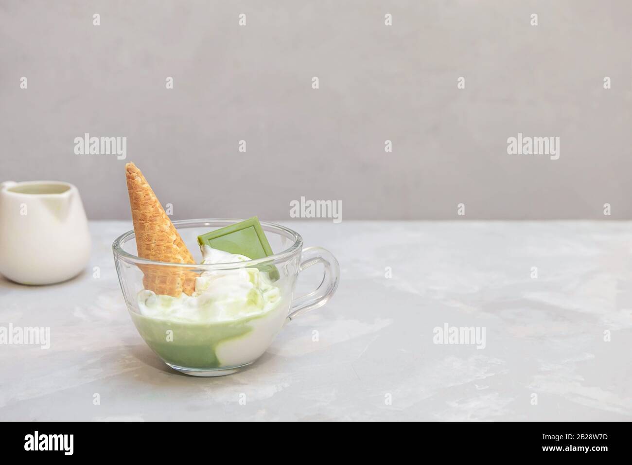 Matcha Affogato Rezept mit Vanilleeis und gesundem Matcha grünen Tee in einer Glaskasse auf grauem Hintergrund, Kopierraum Stockfoto