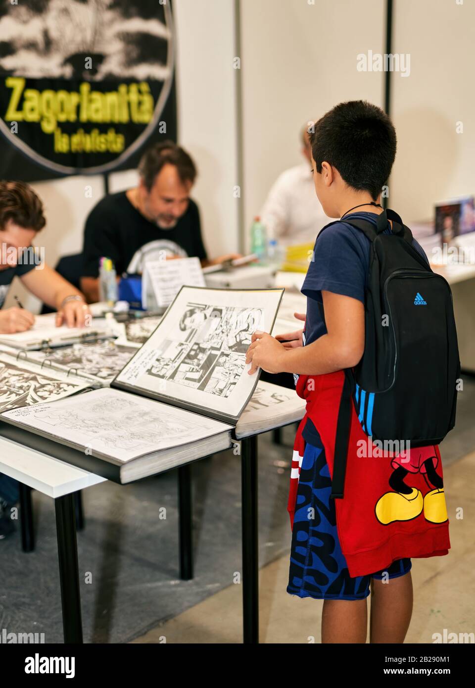 Young Boy schaut sich die Comic-Zeichnungen des ROMICS Festivals an (Rome Comics), zweimal im Jahr das ikonische Treffen der Comic-Liebhaber Stockfoto