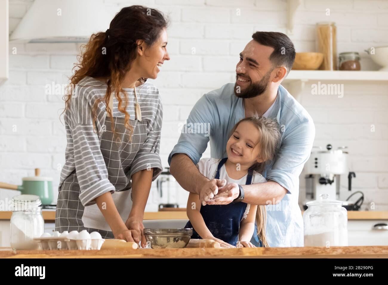 Junge Eltern haben Spaß beim Backen mit kleiner Tochter Stockfoto