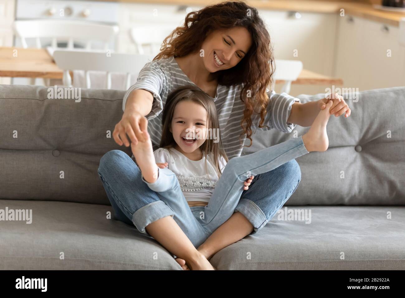 Glückliche Mutter, die zu Hause mit einem kleinen Mädchen spielt Stockfoto