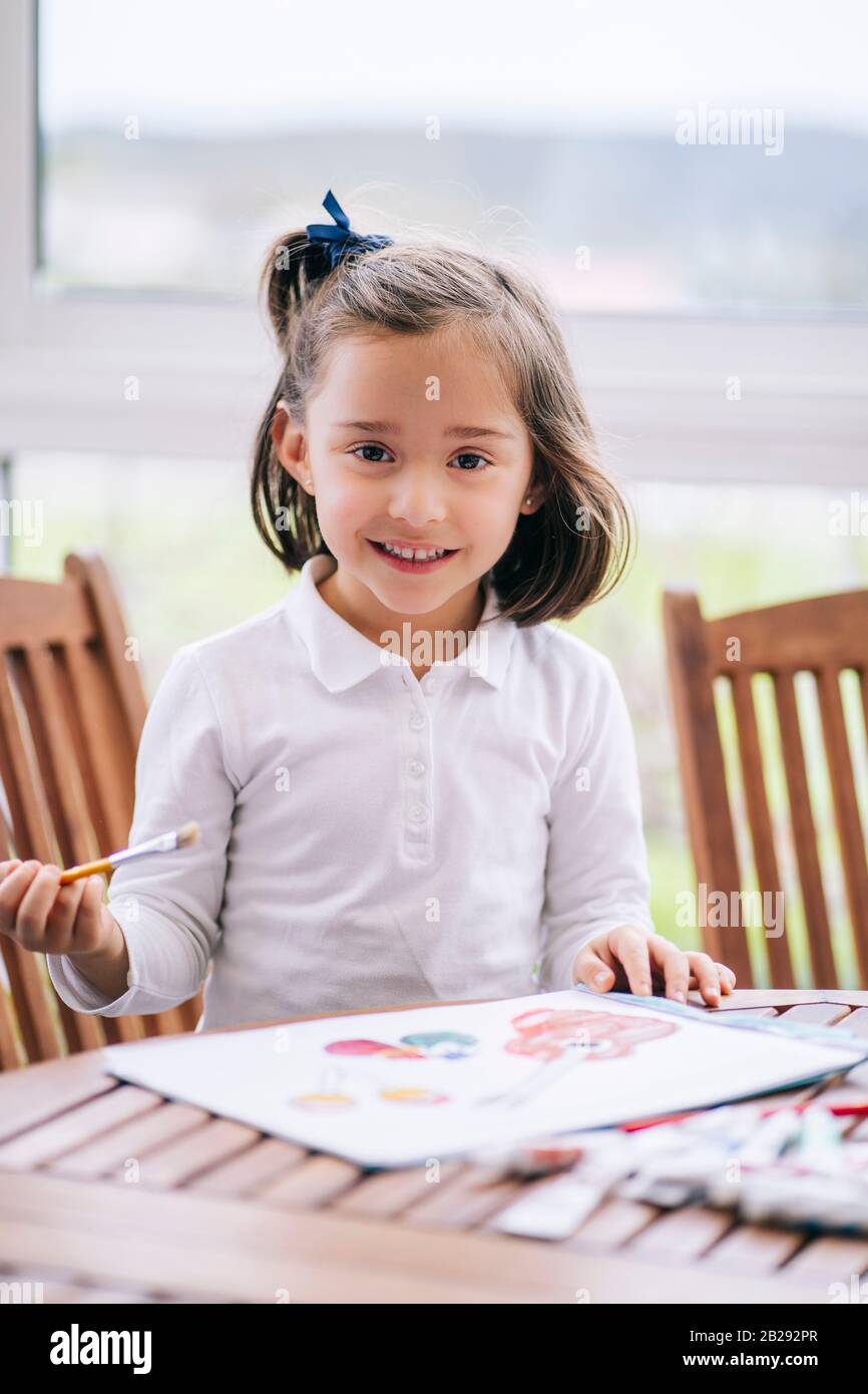 Ein Mädchen malt einige Zeichnungen mit Aquarellfarbe Stockfoto