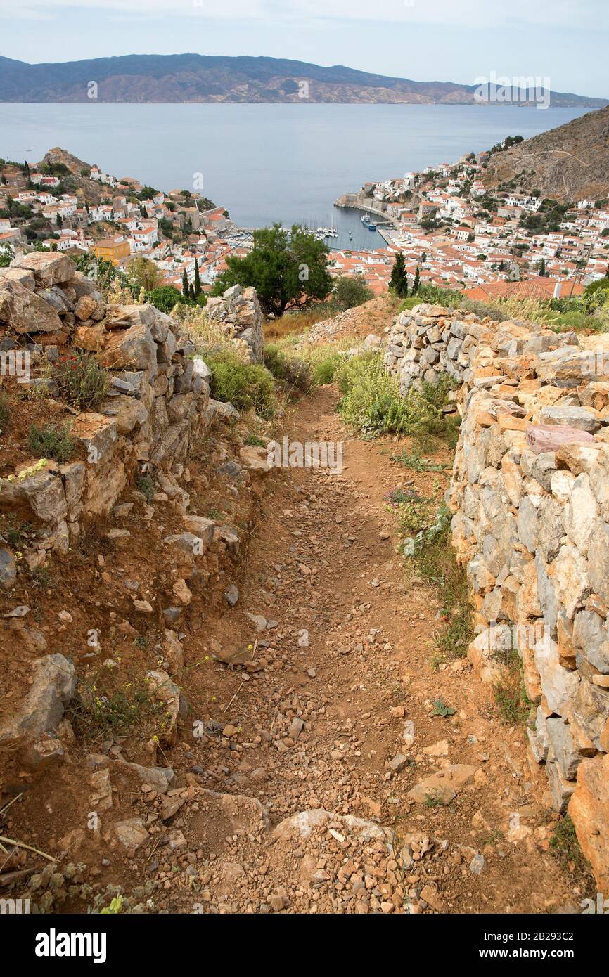 Felsiger Schmutzpfad und Steinmauern über der Stadt Hydra Hafen und Hafen auf der Insel Hydra, Griechenland in der ägeischen See Stockfoto