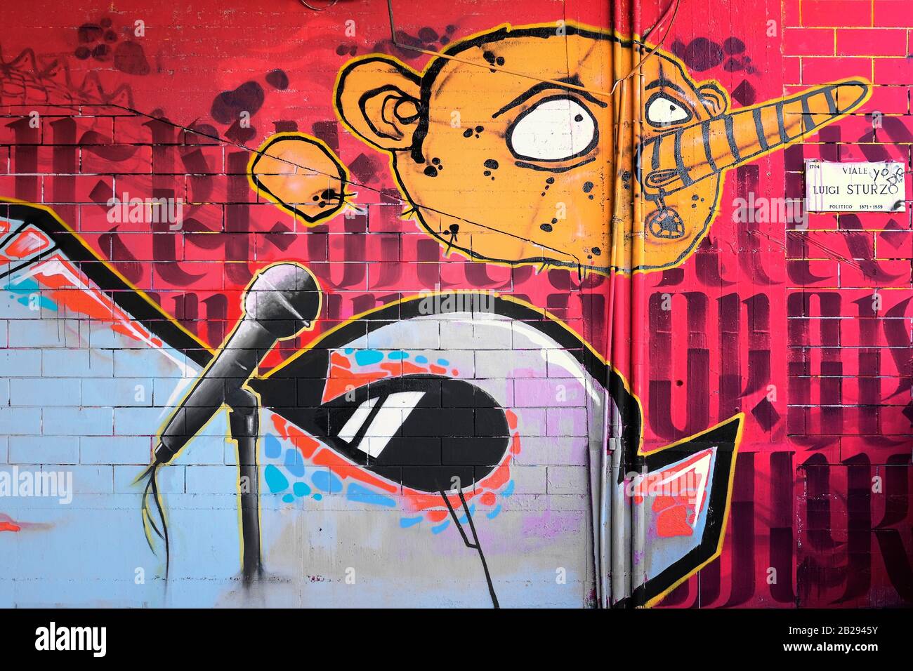 Moderne Graffiti in Der Via Sturzo, Mailand, Italien, die die Karikatur eines menschlichen Gesichts mit einer großen Nase und einem Alien mit einem Standmikrofon darstellen Stockfoto