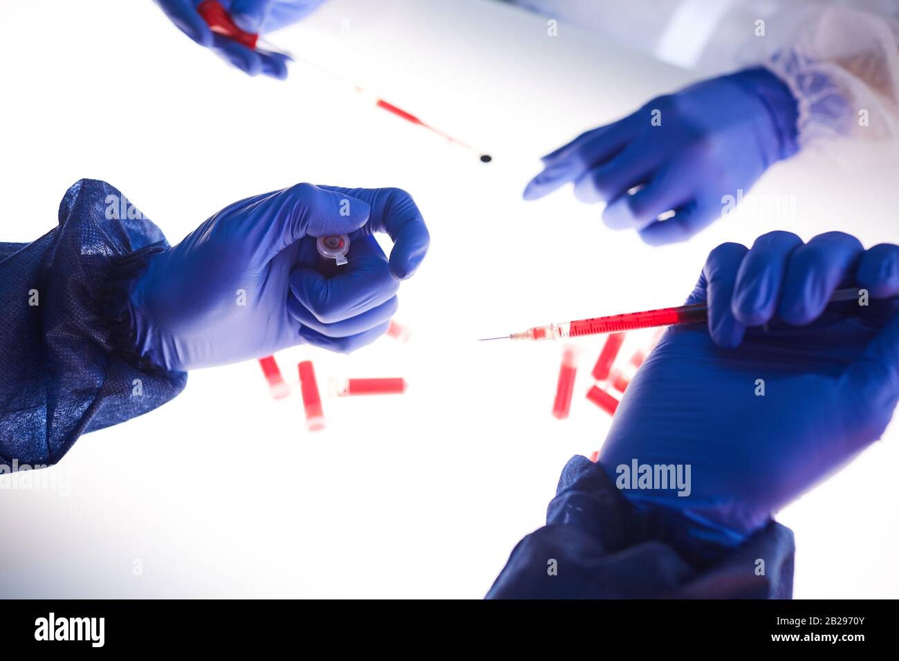 Nahaufnahme des Hintergrunds zweier Wissenschaftler, die Blutproben über dem Lichtfeld im medizinischen Labor untersuchen, Kopierraum Stockfoto