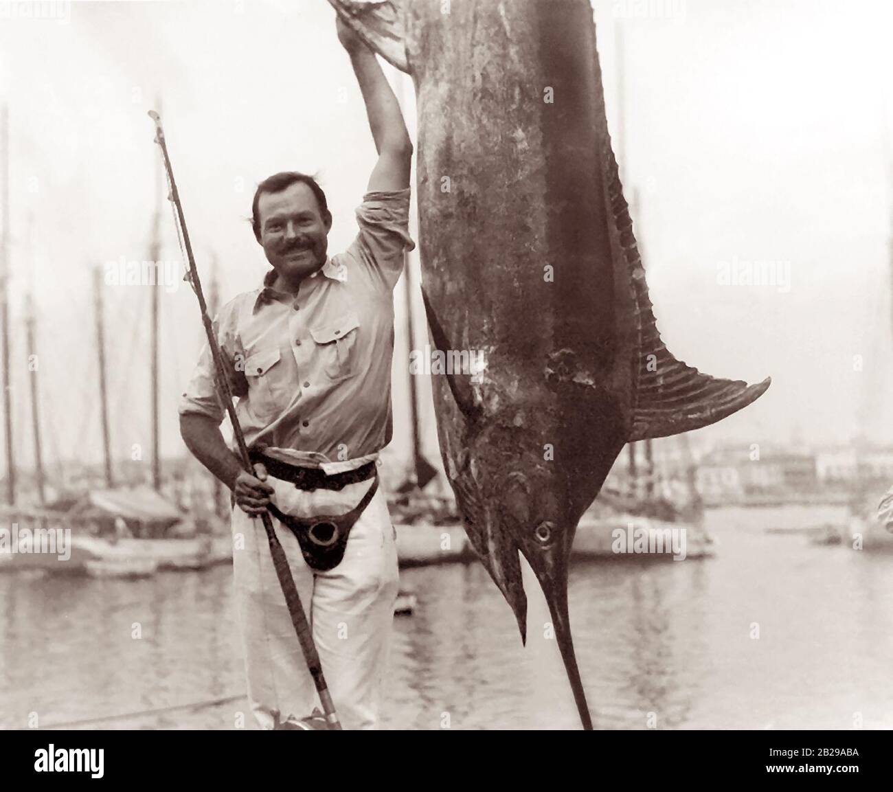 Ernest Hemingway (1899-1961) posierte mit einem Marlin im Hafen von Havanna, Kuba, Juli 1934. Stockfoto