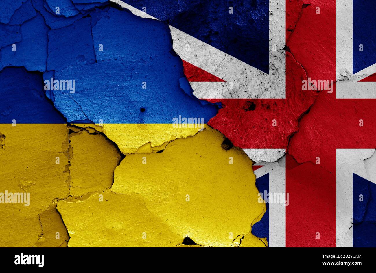 Flaggen der Ukraine und Großbritanniens auf gerissene Wand gemalt Stockfoto