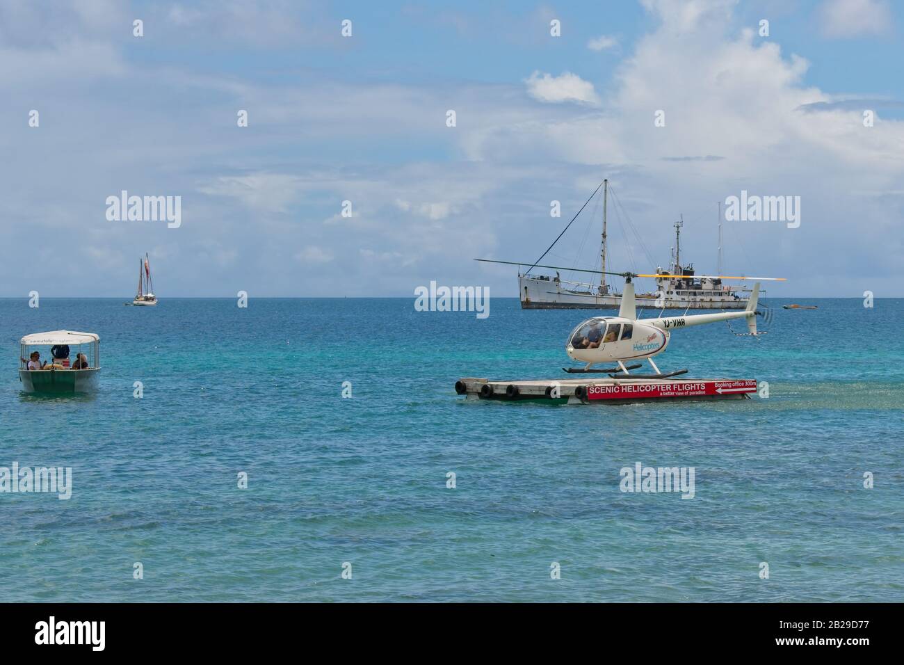 Port Vila, Vanuatu - 14. Februar 2020: Touristen im Boot, die auf einen Hubschrauber warten, um einen Rundflug über die Korallenriffe und den Dschungel Canyon zu erreichen. Stockfoto Port Vila, Vanuatu - 14. Februar 2020: Touristen im Boot, die auf einen Hubschrauber warten, um einen Rundflug über die Korallenriffe und den Dschungel Canyon zu erreichen. Stockfoto