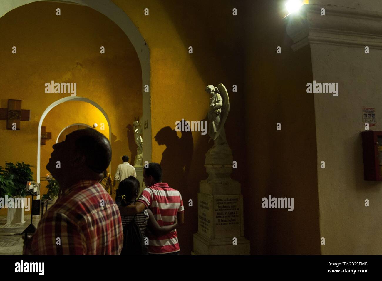 In einer Kirche in Cartagena, Kolumbien, wirft ein Engel einen Schatten neben den Gläubigen Stockfoto