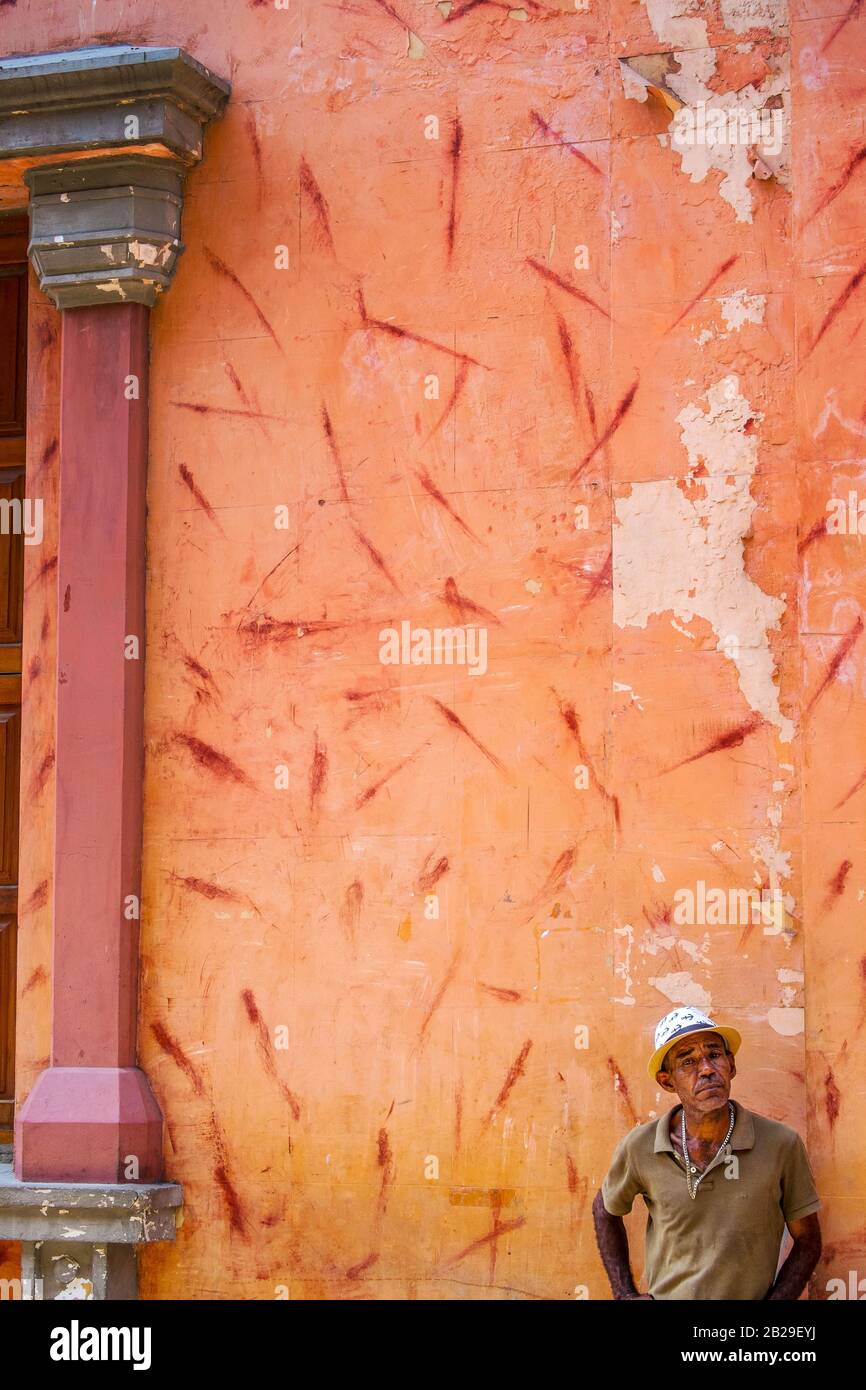 Ein Mann steht neben einer Wand mit roten Streifen in Cartagena, Kolumbien Stockfoto