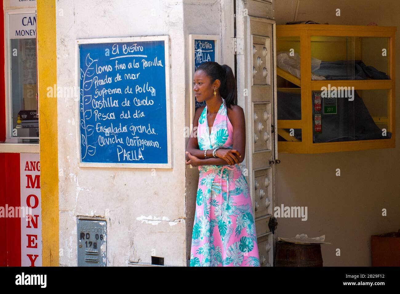 Eine Frau steht vor einem Restaurant in der ummauerten Stadt Cartagena, Kolumbien, an einer Speisekarte Stockfoto