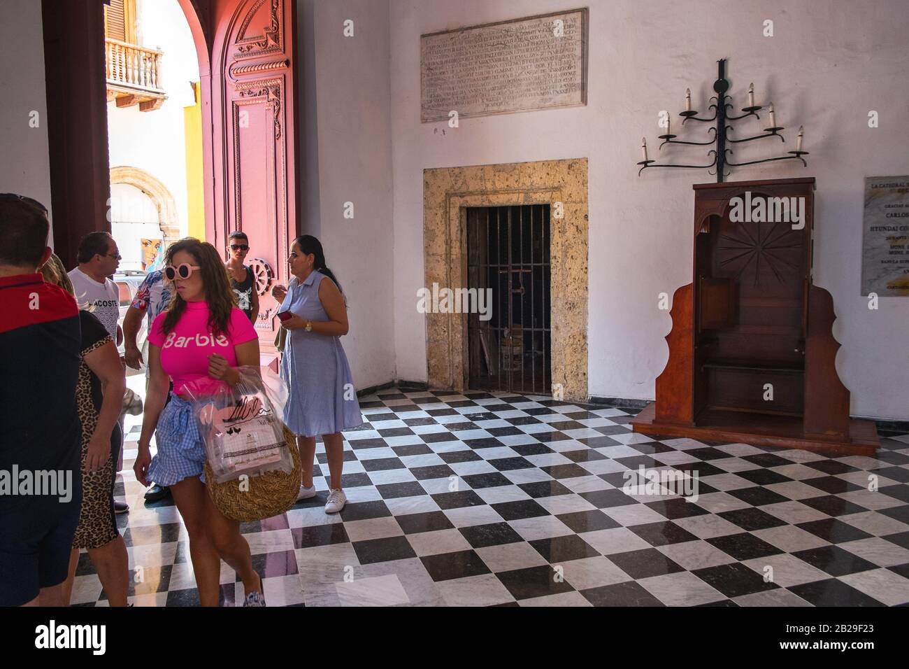 Eine Frau in einem rosa Barbie-Hemd in einer historischen Kirche in Cartagena, Kolumbien Stockfoto