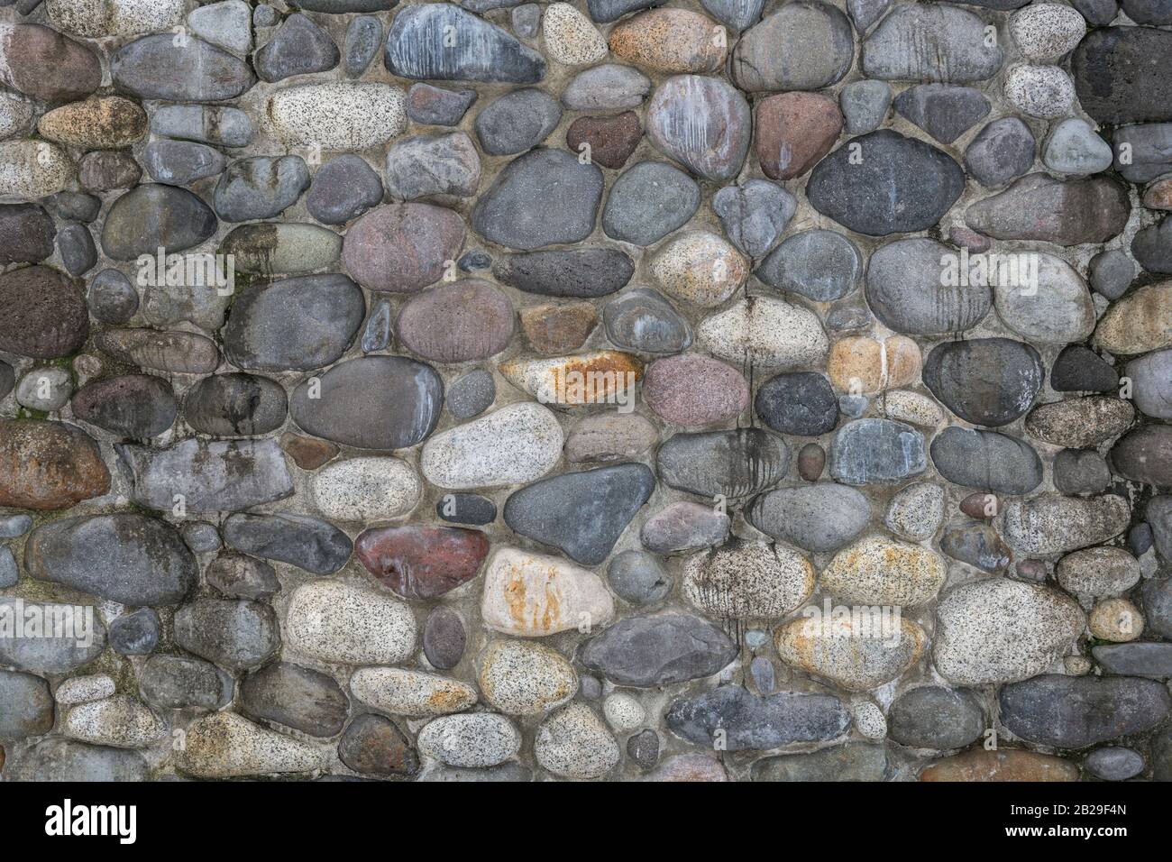 Glatte Flusssteinmauer Stockfoto