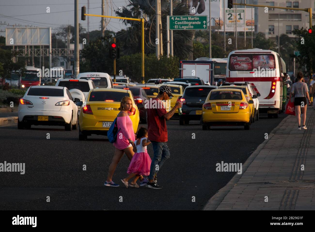 Eine Familie geht über eine Straße in Cartagena, Kolumbien Stockfoto
