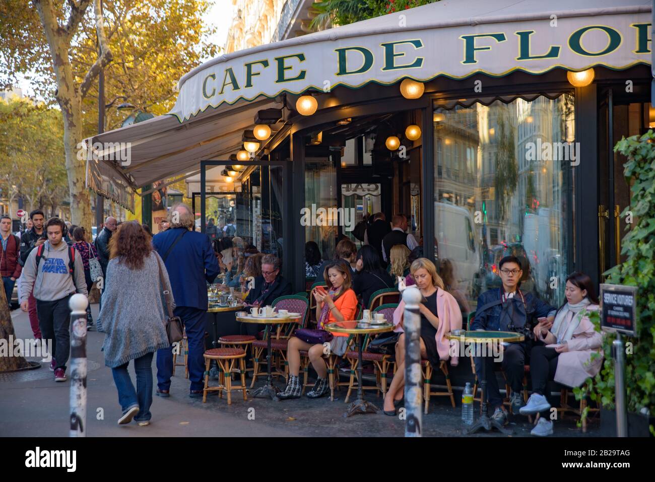 Die Leute, die im Freien im Café de Flore, einem berühmten Café in Paris, in Frankreich, Kaffee trinken Stockfoto