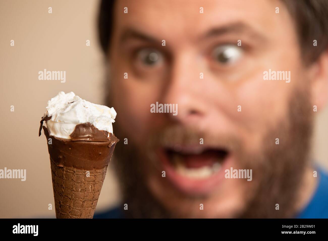 Mann, der beim Blick auf Eis ein verrücktes Gesicht zeigt Stockfoto