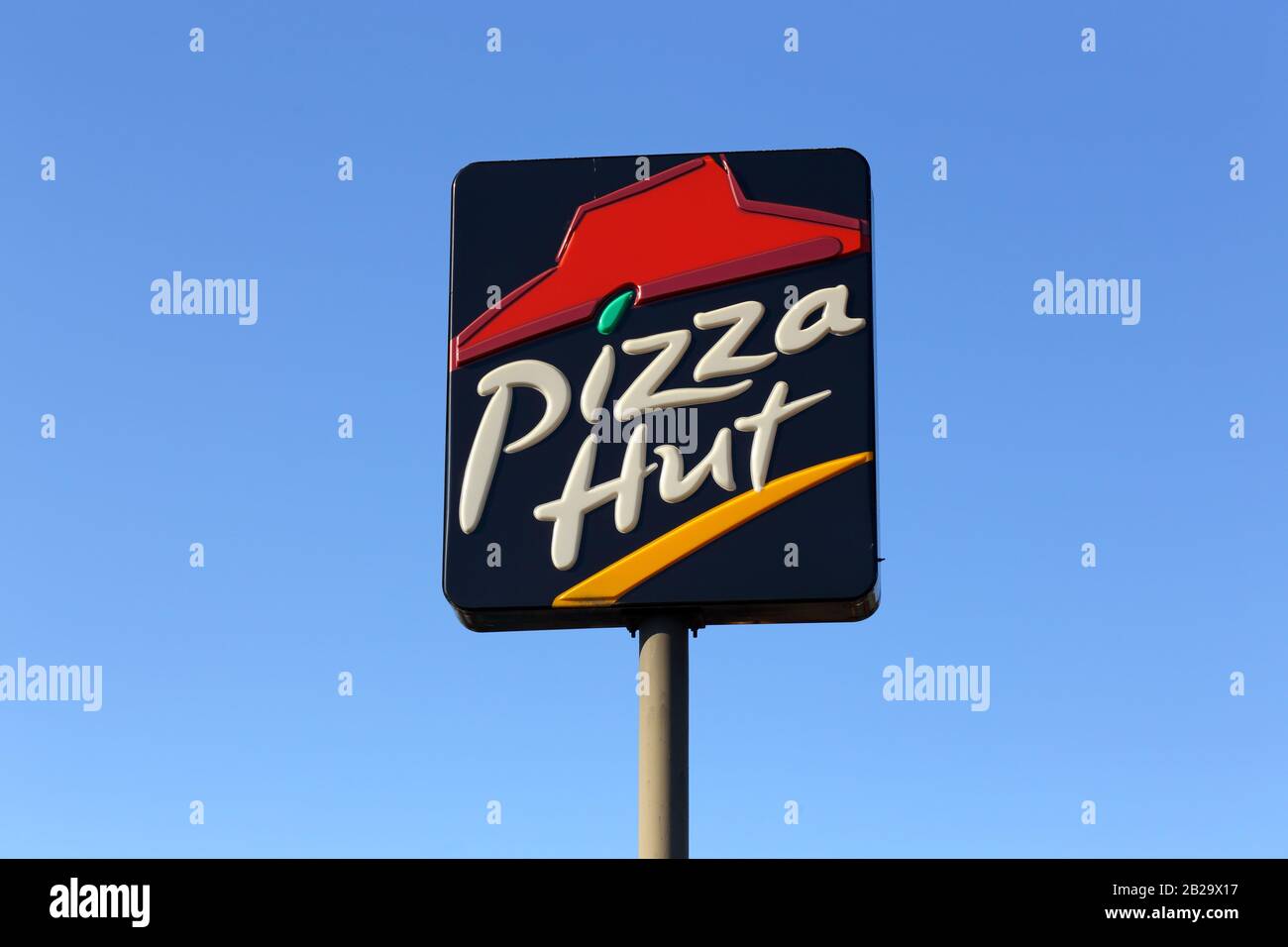 Ein Schild mit Pizza Hut auf einem Pfosten gegen einen blauen Himmel. Stockfoto