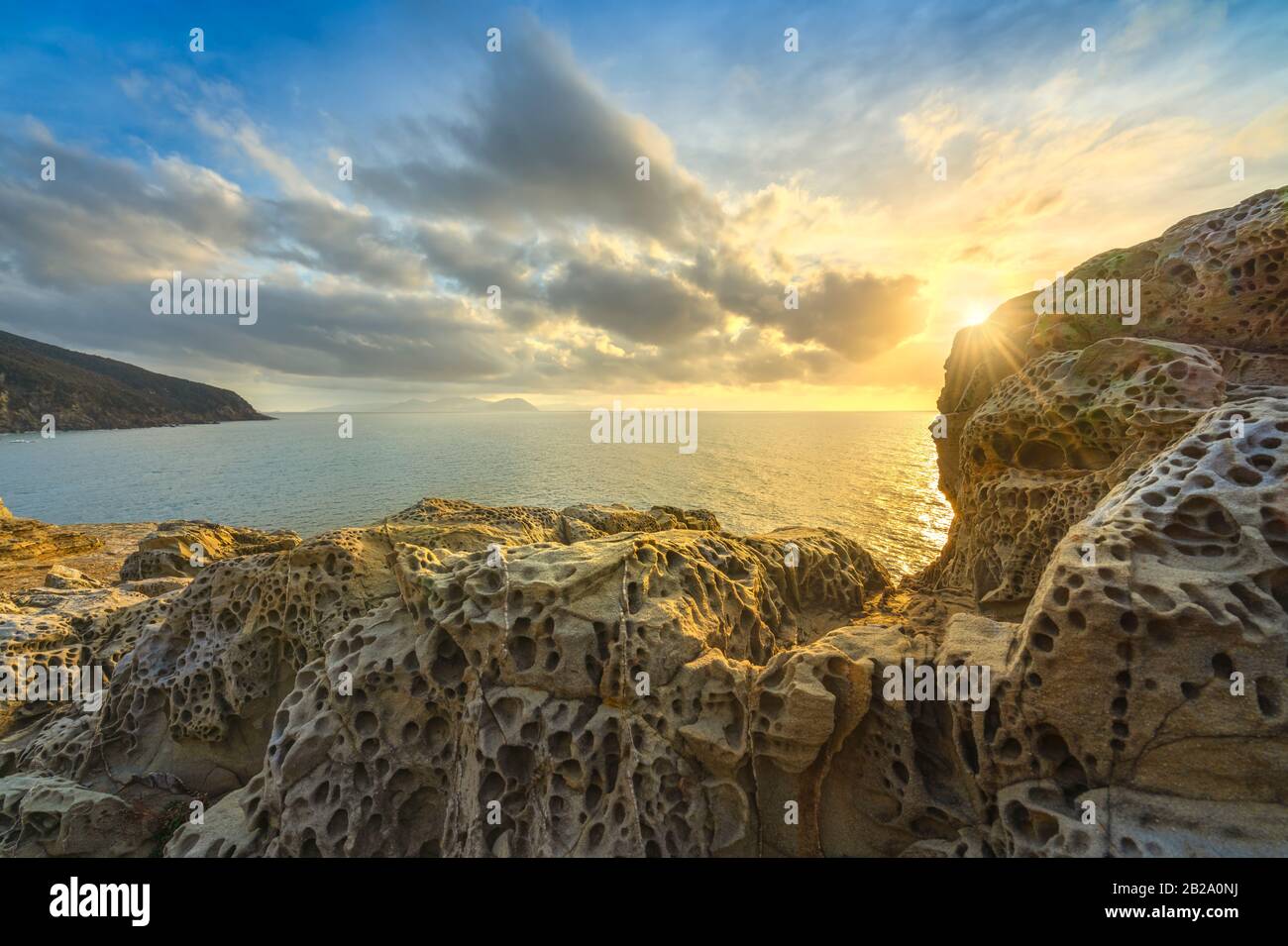 Felsen erodiert durch Wind und Meer in der Populonia-Klippe Buca delle Fate bei Sonnenuntergang. Piombino, Maremma Toskana, Italien. Stockfoto