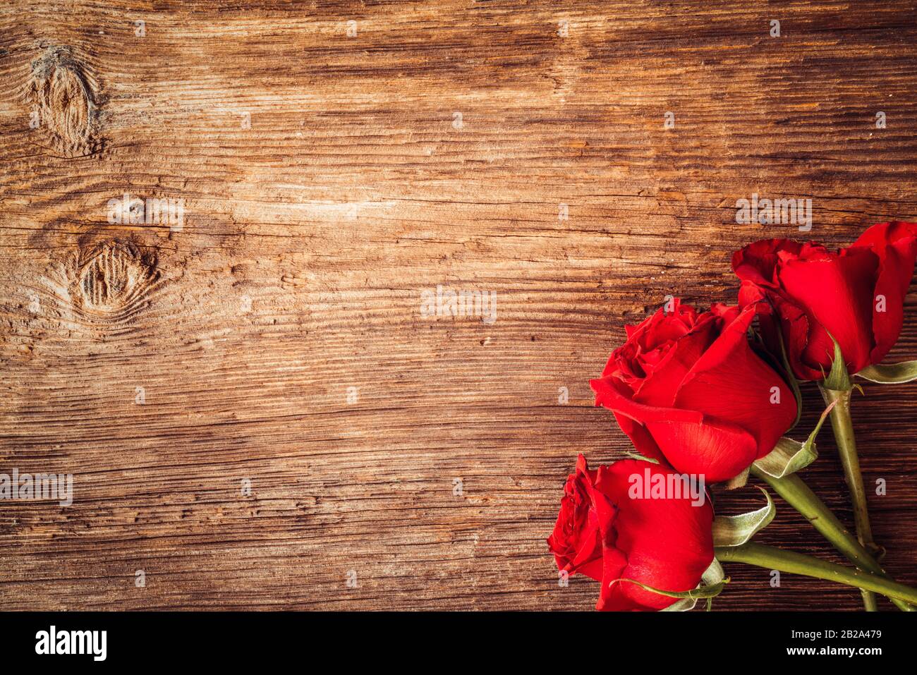 Rahmen mit scharlachroten Rosen für Valentinstag Verzierungen Konzept mit Holzhintergrund. Liebe und Romantik Stockfoto